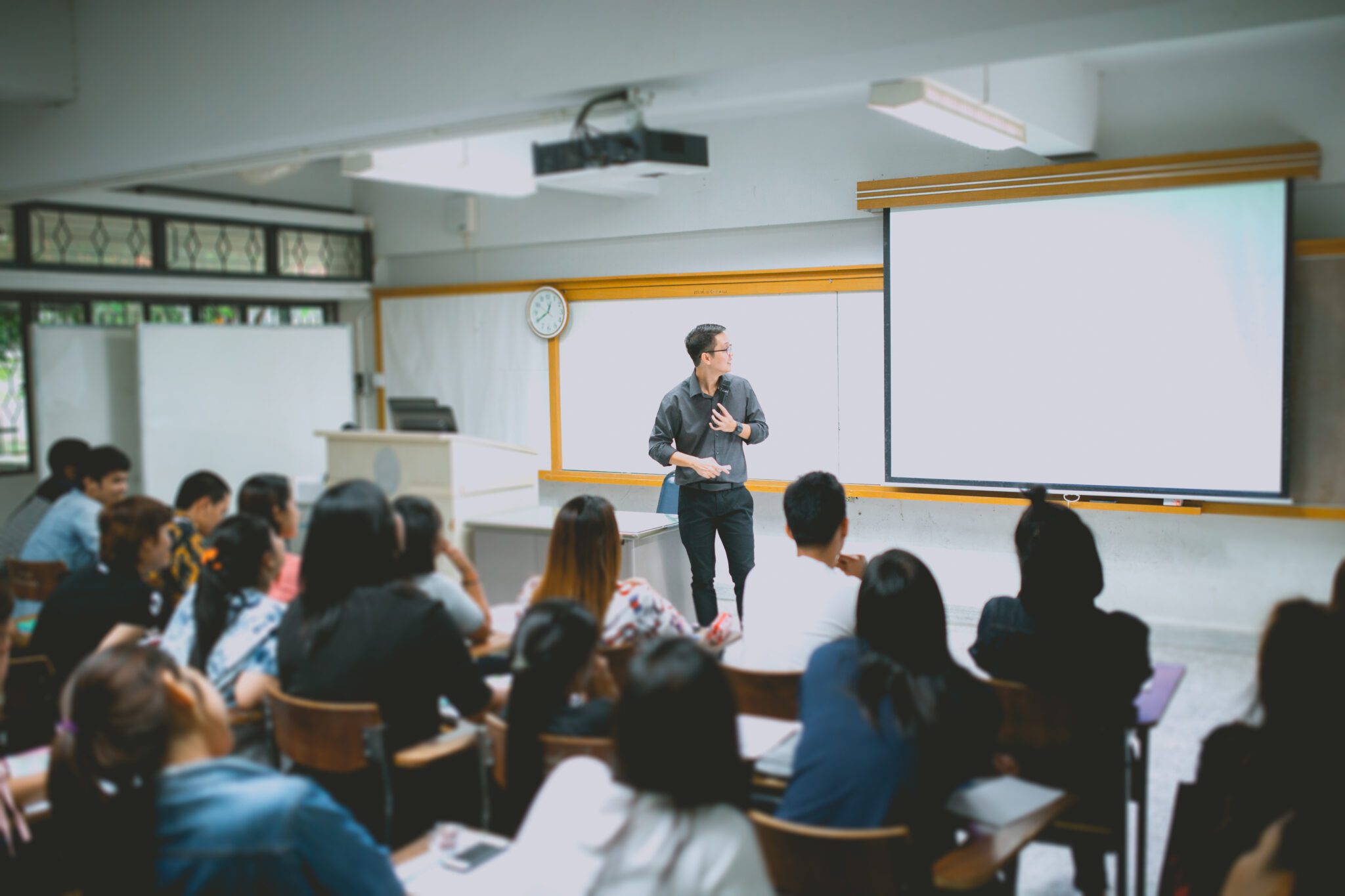 Teacher teaching studen in classroom at university.